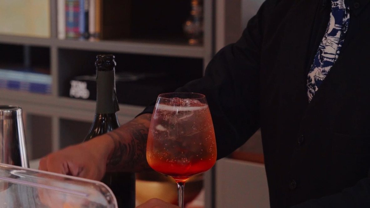 A spritz in a wine glass on the bar